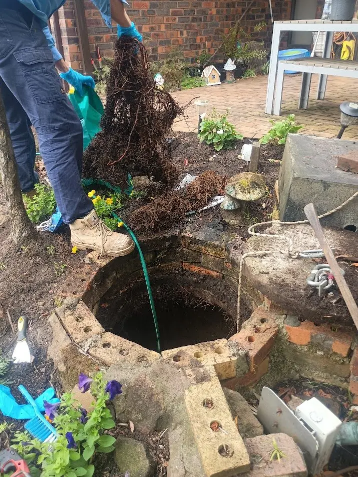 Ayden lifting massive root mass from a brick pump pit during service in Yowie Bay