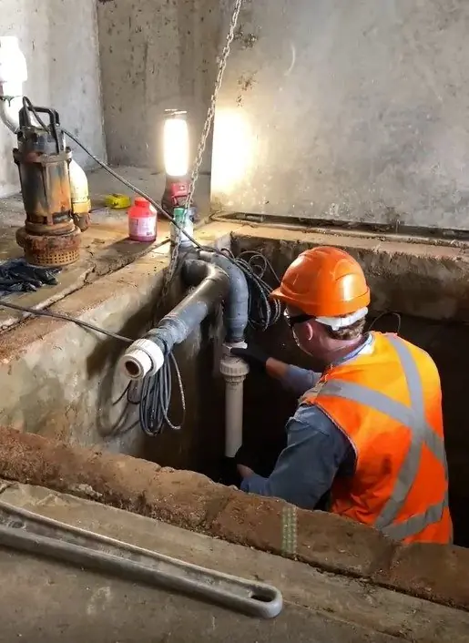 A pump specialist working on a pump system in a Sydney strata pit
