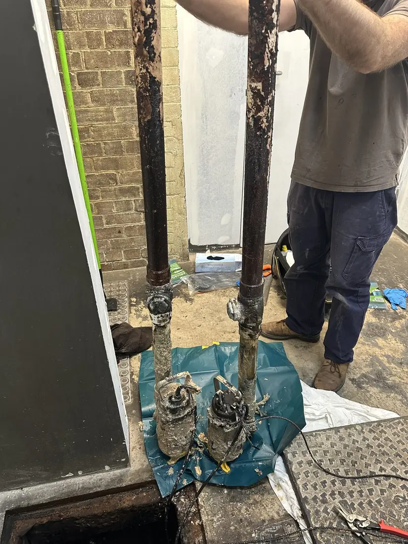 Two grease trap pumps lifted from a Sydney commercial pit, caked in fat buildup
