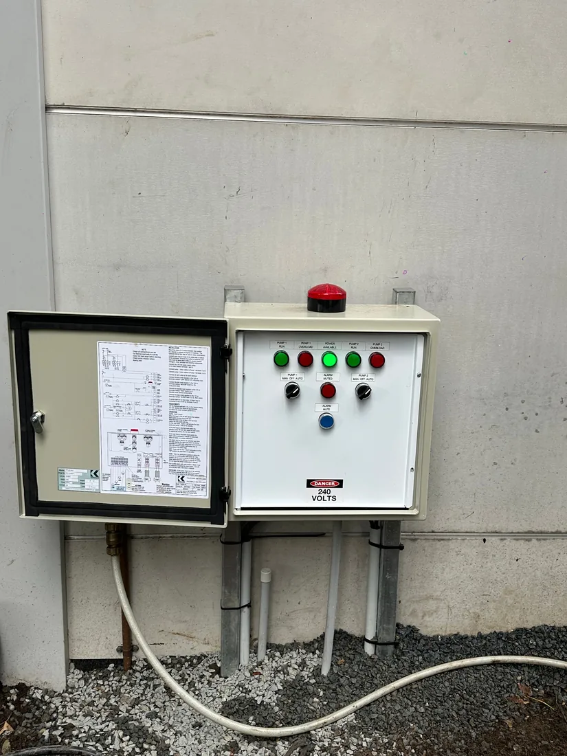 The replacement Kenrahn dual-pump control panel at Five Dock, mounted and wired with the door open showing the schematic