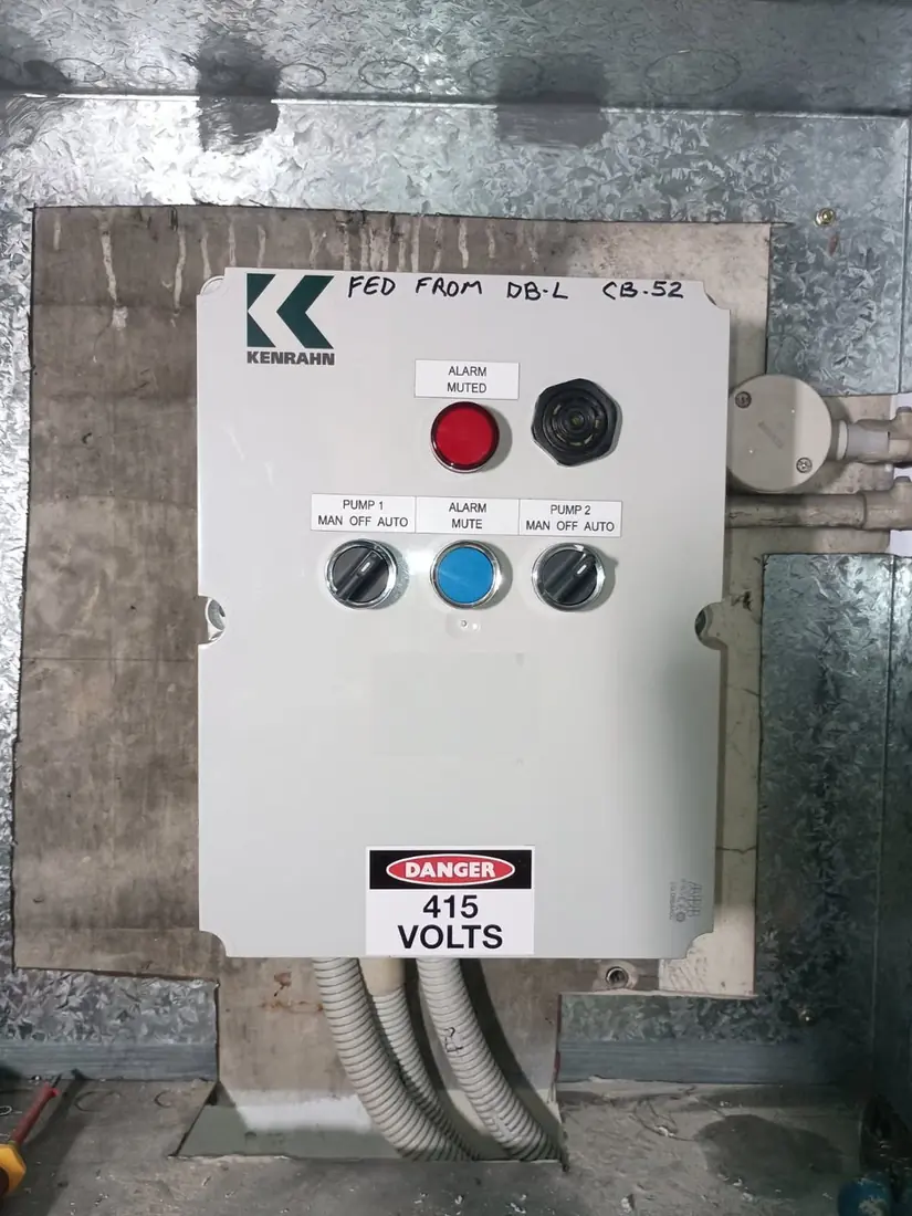 A Kenrahn dual-pump control panel with Pump 1 and Pump 2 MAN-OFF-AUTO selectors, an alarm light and mute button, marked DANGER 415 volts
