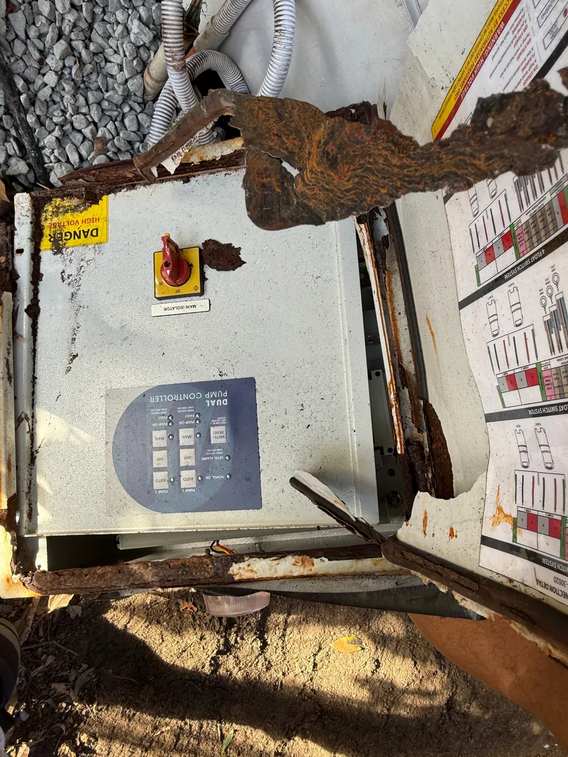 An old dual-pump controller at Five Dock, Sydney, rusted through and removed, with its DANGER label and isolator still attached