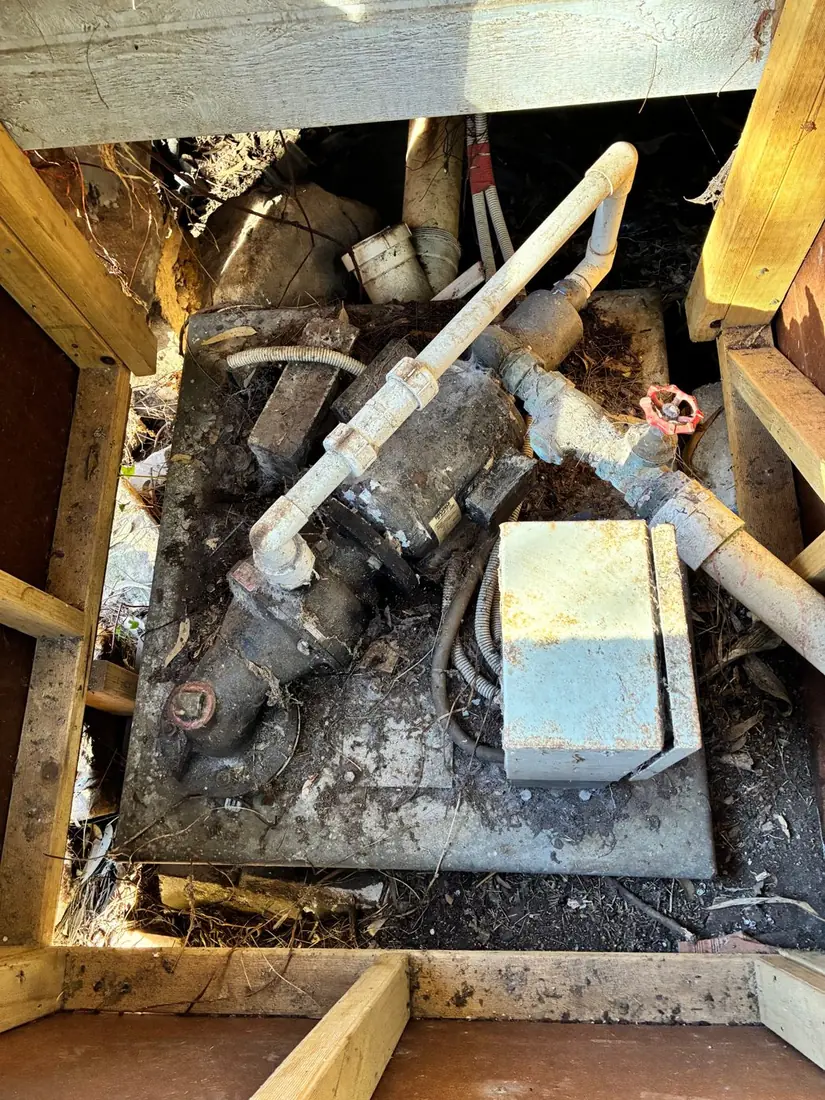 An original above-pit Mono pump with motor and control box mounted on a concrete slab over the tank at a Sydney property