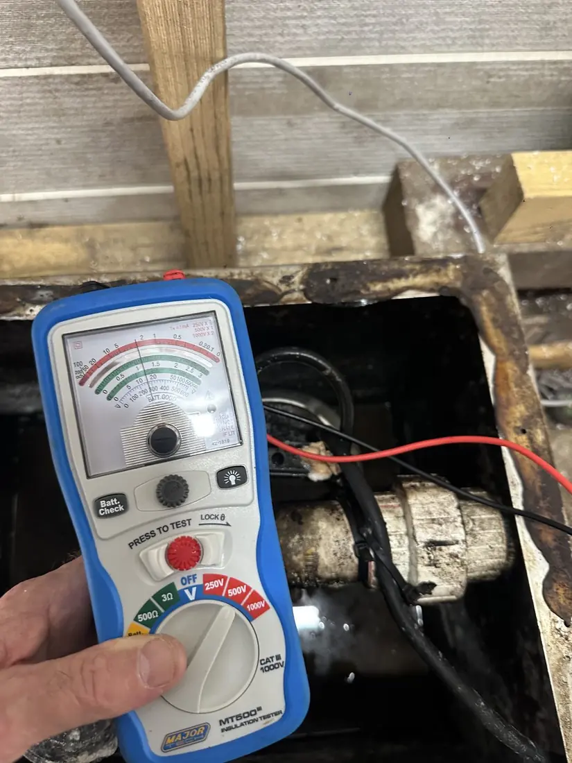 Insulation resistance megger test in progress on a pump motor during scheduled service, leads connected to motor terminals