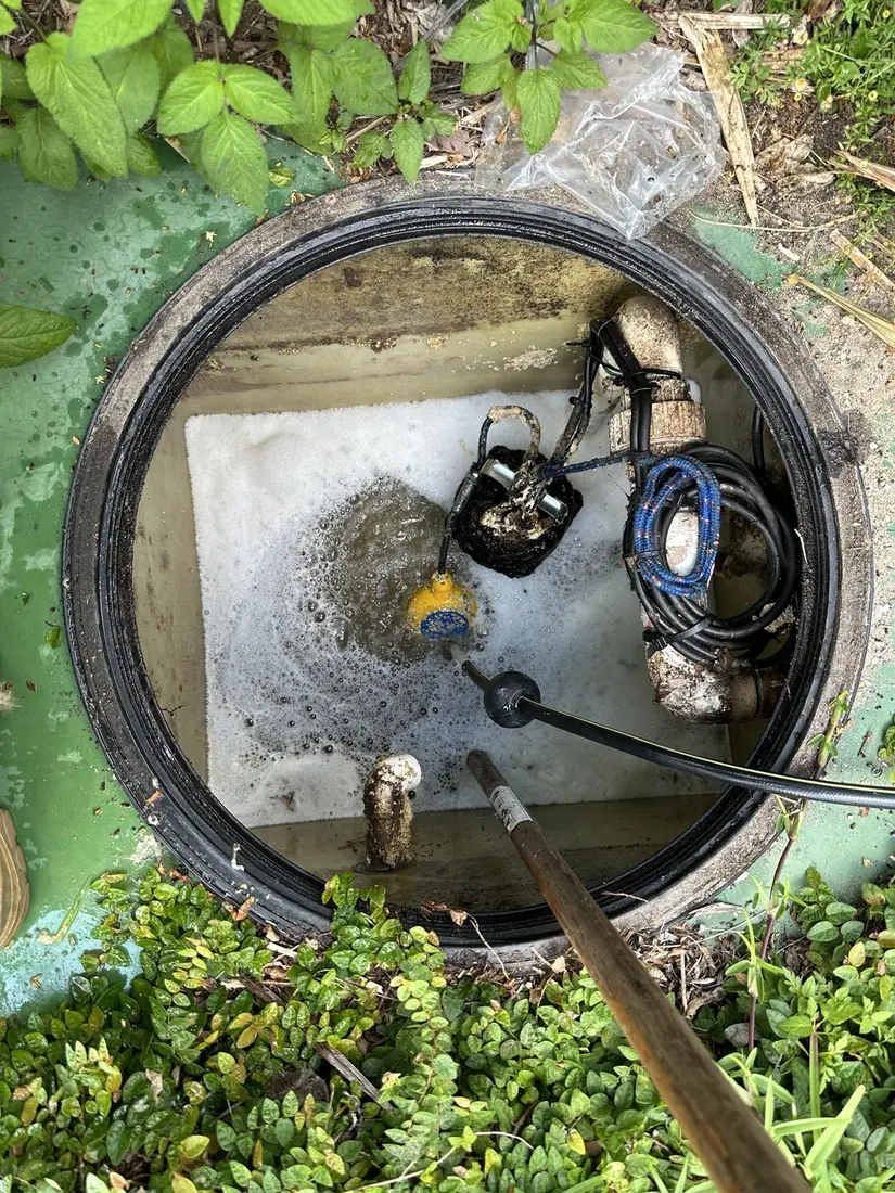 The same sewer pump pit cleared out, with the submersible pump, float switches and pipework visible inside