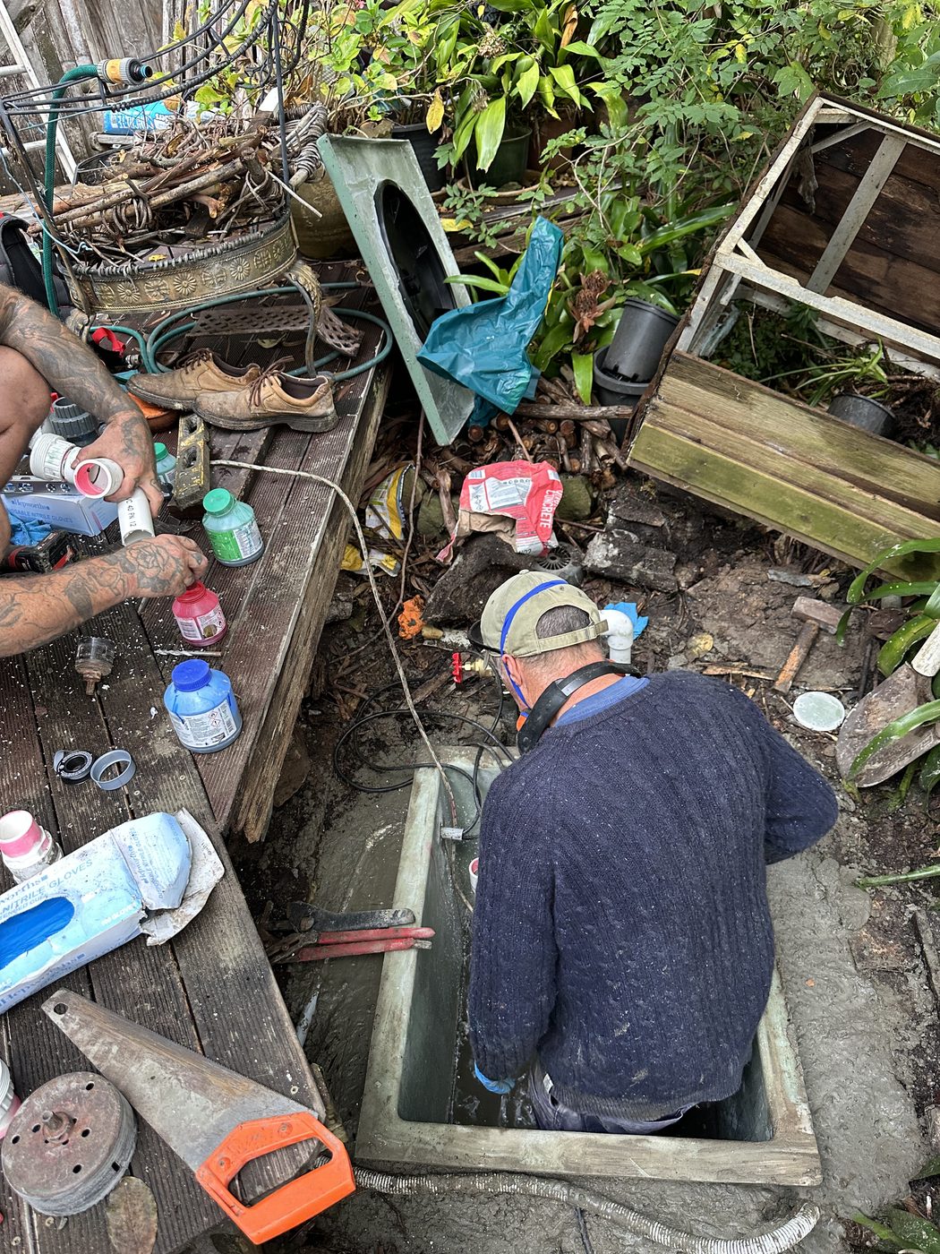 Sewer Pump Services on site installing the new pit — one working down in the chamber, one preparing PVC pipework
