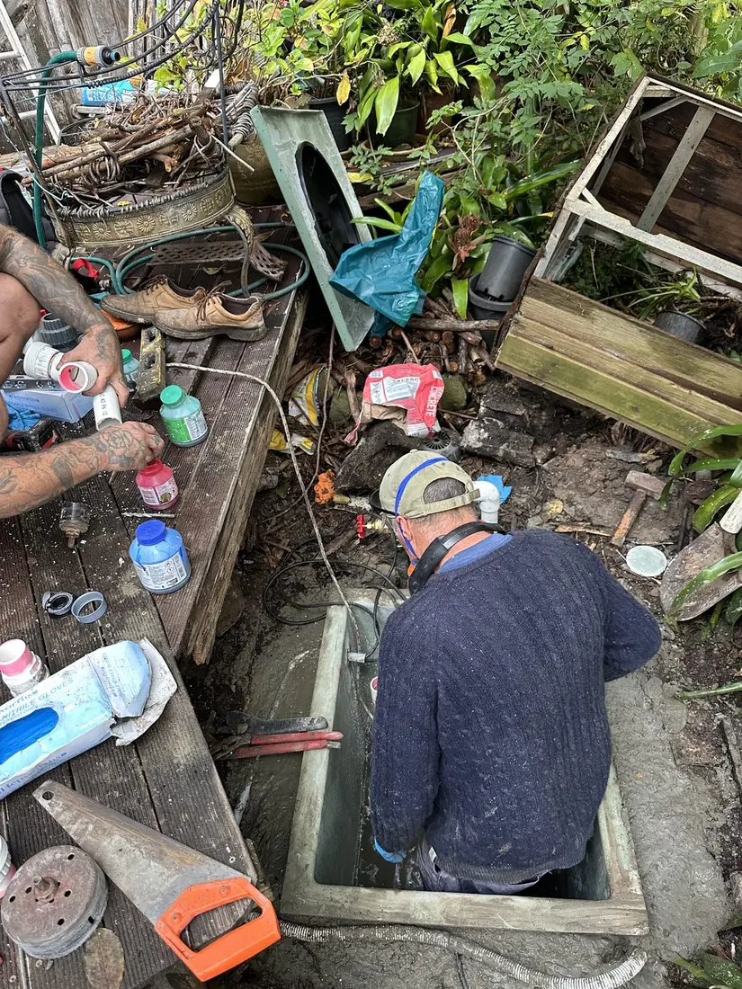 Sewer Pump Services on site installing the new pit — one working down in the chamber, one preparing PVC pipework