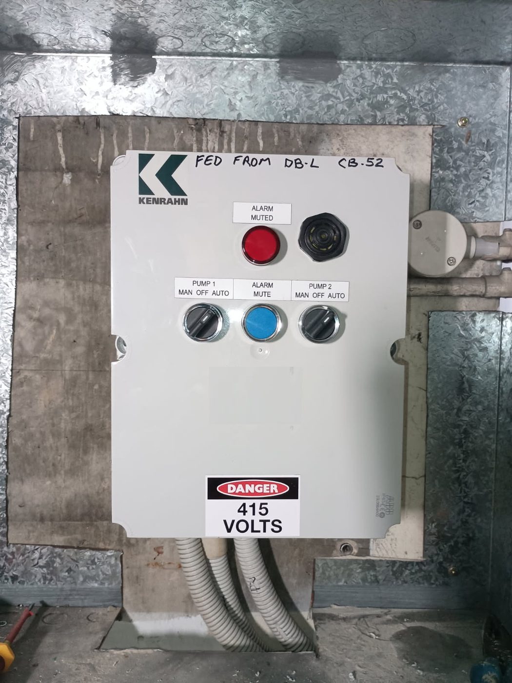 Kenrahn dual-pump alarm panel servicing a Sydney strata stormwater system — alarm muted indicator, pump one and pump two manual-off-auto selector switches, alarm mute button visible