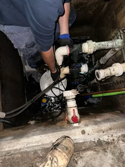 Stuart Opperman, founder of Sewer Pump Services, working hands-on inside a stormwater pit in Cronulla — decades of plumbing and pump trade experience